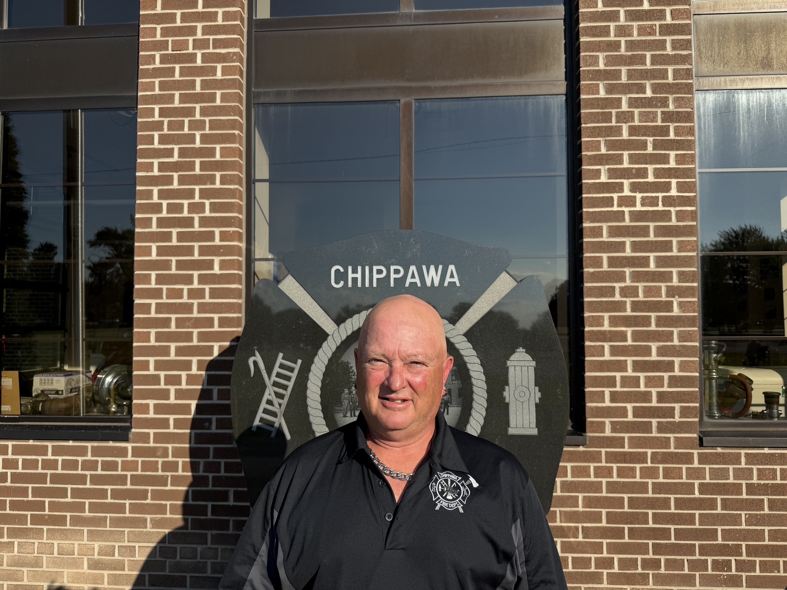 Brian Winrow standing in front of the Chippawa fire hall sign